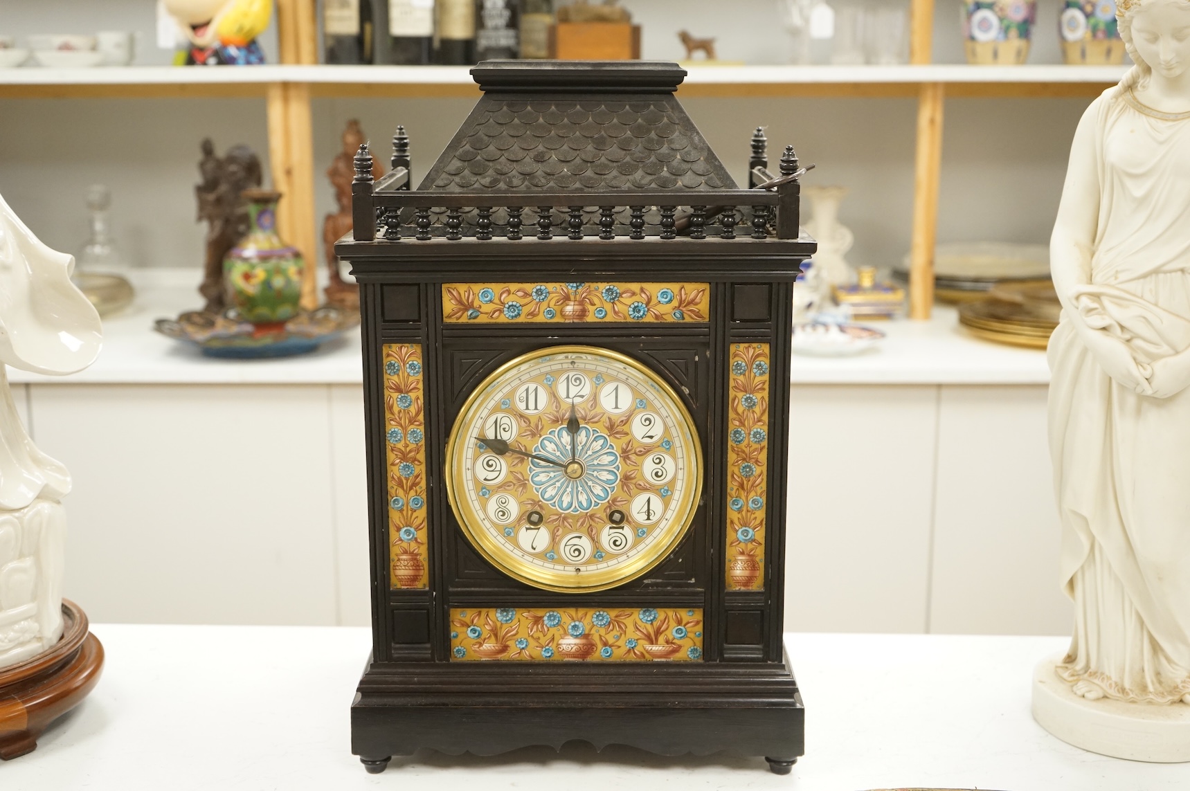 A Victorian Aesthetic Movement ebonised architectural mantel clock, probably designed by Lewis Foreman Day, the eight day chiming movement marked G.V. no. 39837, with Elourdelet lever, with figure and foliage decorated g